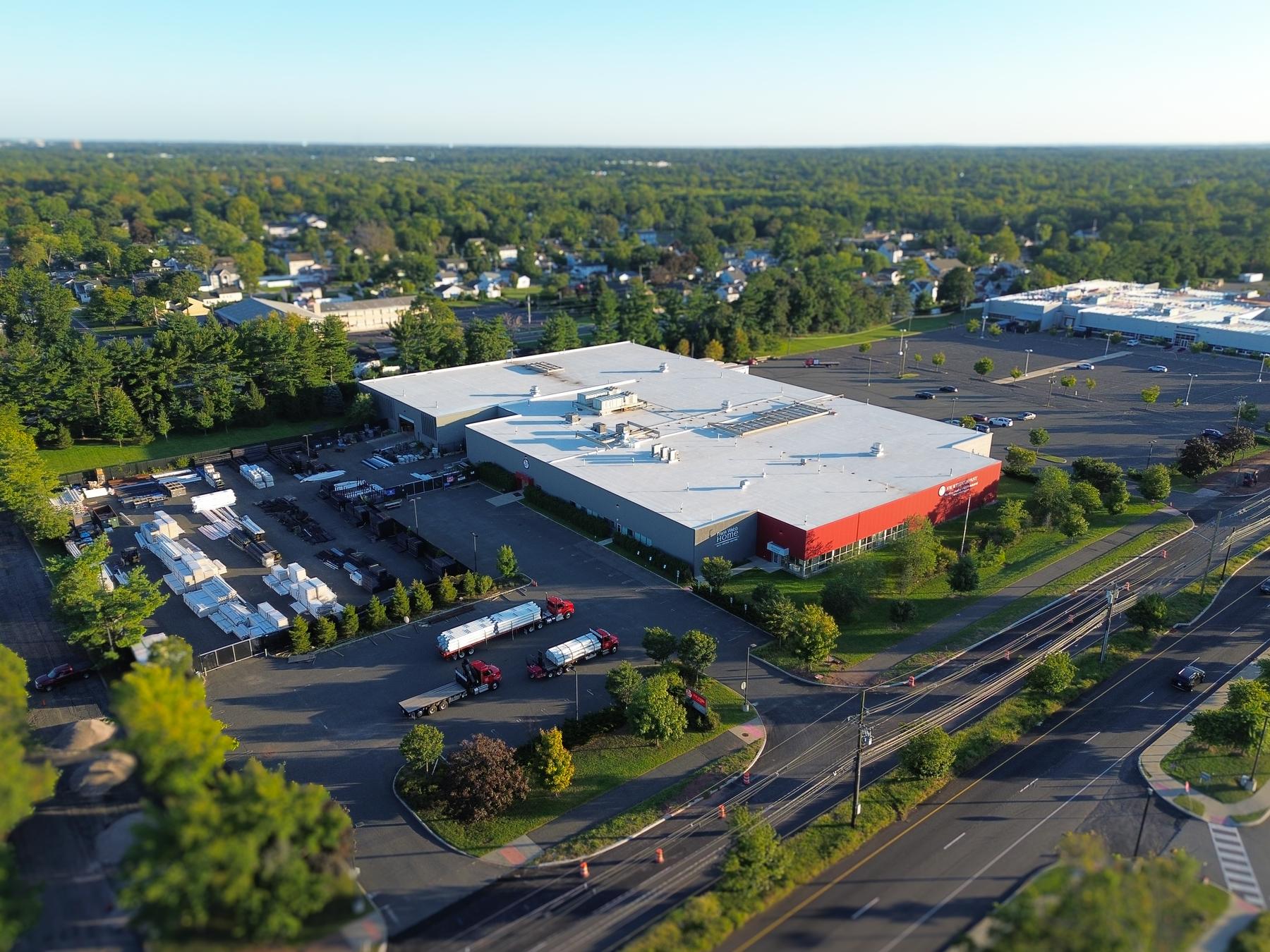 Aerial of 180 Centennial Avenue: the building, red front elevation, outside-storage yard, truck court and frontage on Centennial Avenue