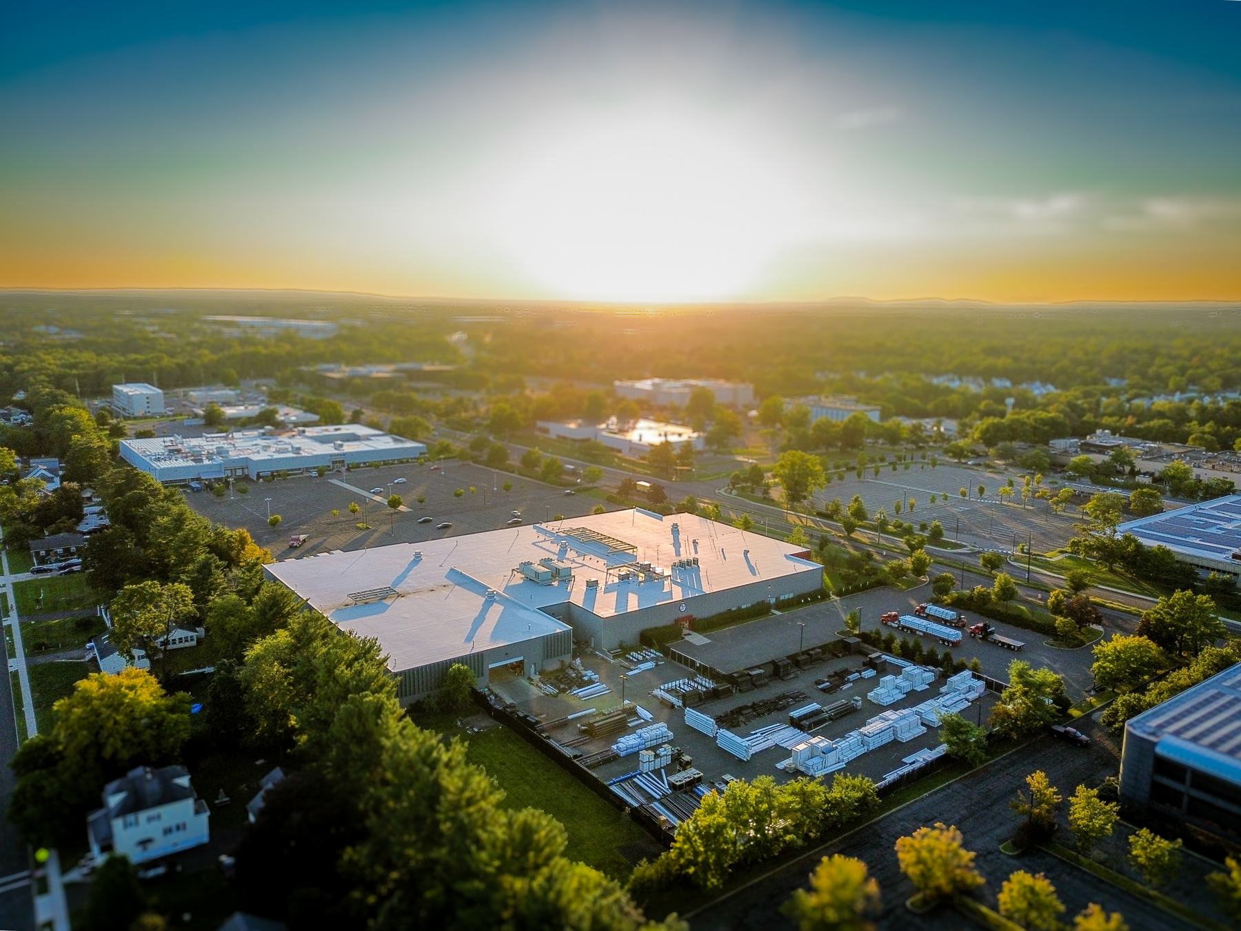 Sunset aerial of the building, fenced yard and flatbed staging